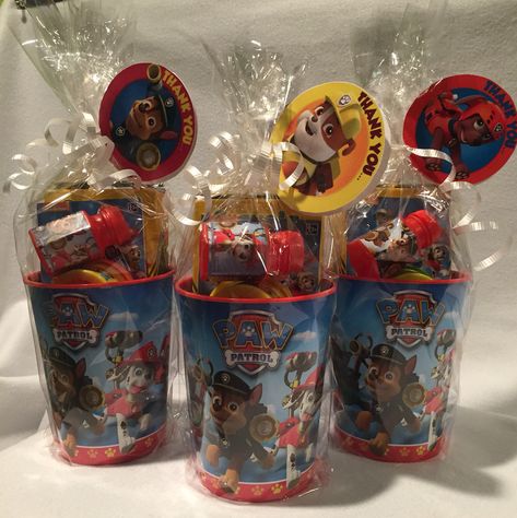 Paw Patrol Party Favors  • hard plastic cups  ($.69@Christmas Tree Shops)  • Crayola crayons (Amazon for about $.70/ea.) • Paw Patrol mini activity book (Party City for $.10/ea) • Mini play-doh (10 pack for $4.99 @ Christmas Tree Shops) • Mini Paw Patrol bubbles (Party City for $.15/ea)  All wrapped in cellophane with a little white curling ribbon with a "lollipop" tag printed from NickJr. for free   Great for ages 2-7 or so. Paw Patrol Candy Table Ideas, Paw Patrol Party Cups, Paw Patrol Party Centerpieces Diy, Paw Patrol Favors Ideas, Paw Patrol Party Bags Ideas, Paw Patrol Favor Bags, Paw Patrol Birthday Favors, Paw Patrol Party Table Ideas, Paw Patrol Goodie Bags Ideas