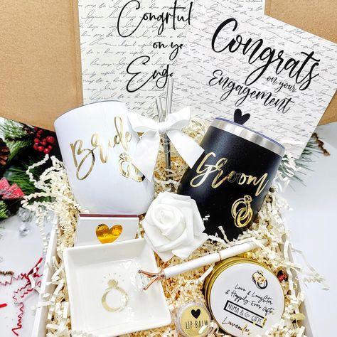 Raise a toast to the newly engaged lovebirds! 🥂🎉 Our Bride and Groom Engagement Gift Box is a hug in a box, packed with delightful goodies to make their hearts soar. Celebrate their journey to “happily ever after” with this perfect gift box 🎁💍✨ Shop now ⬇️ www.nimagifts.com or find us on Etsy ✨ . . . . #engagementgift #bride2be #newlyengaged #engagedcouple #bridesmaidproposalbox #2024bride #personalizedgifts #engagedtobemarried #bridetobe #newbride #weddinginspiration #weddinggifts #wedding... Engagement Gifts For Bride, Engagement Gift Boxes, Engagement Bride, Engagement Party Gifts, Gifts Box, Engagement Gifts For Couples, Unique Bride, Bride And Groom Gifts, Wedding Gift Boxes