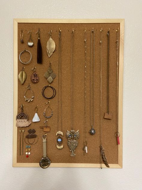 There’s a picture of jewelry hanging off of a corkboard on a wall. The jewelry is hanging by tiny gold hooks described in the description. Cork Board Jewelry, Diy Cork Board, Diy Cork, Cork Diy, Hanger Organizer, Jewelry Board, Jewelry Hanger, Jewelry Boards, Diy Box