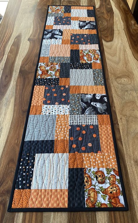 Two occasions in one! One side of this table runner is made from modern Halloween fabrics with traditional colours of black and orange, as well as pumpkins and ghosts. The reverse side is modern black and white fabric depicting deer. The two sides are separated by a purposeful blue band of fabric that looks like stars in the sky. It would suit winter or Christmas décor, but could be used year round if this is your colour scheme. It is quilted together with unique wavy line quilting. Simple Quilt Table Runners, Quilted Halloween Table Runners, Modern Quilted Table Runner, Halloween Table Runners Quilted, Halloween Quilts Ideas, Quilt Table Runners, Winter Table Runner, Quilt Runners, Christmas Table Runner Pattern