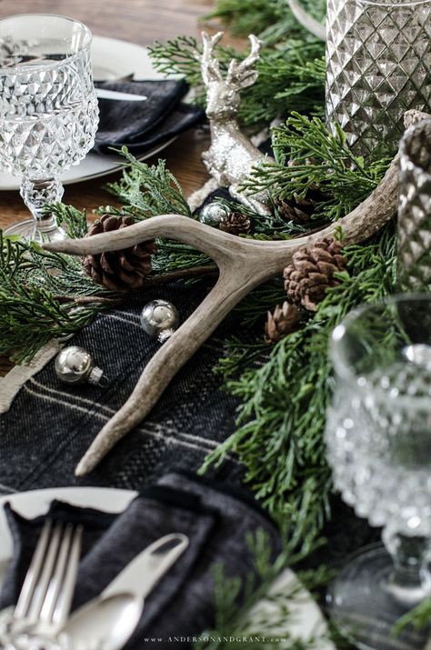 This rustic woodland centerpiece was created using greenery, mercury glass, silver deer, and antlers. #christmas #tablescape #centerpiece #christmastablescape #andersonandgrant Woodland Centerpiece, Viking Christmas, Woodland Christmas Decor, Antler Christmas, Noel Fisher, Christmas Dining Table, Natural Christmas Decor, Tablescape Ideas, Holiday Table Settings