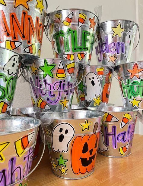 These hand painted, personalized Halloween buckets are perfect for gift giving, decorations, or trick or treating. Painted to order, sealed for protection, and shipped to you for spooky season!  Approximately 7x6" Painted Trick Or Treat Bags, Painted Trick Or Treat Buckets, Diy Halloween Bucket, Diy Halloween Buckets For Kids, Diy Halloween Baskets For Kids, Hand Painted Items To Sell, Hand Painted Crafts, Painted Halloween Buckets, Painted Buckets Ideas