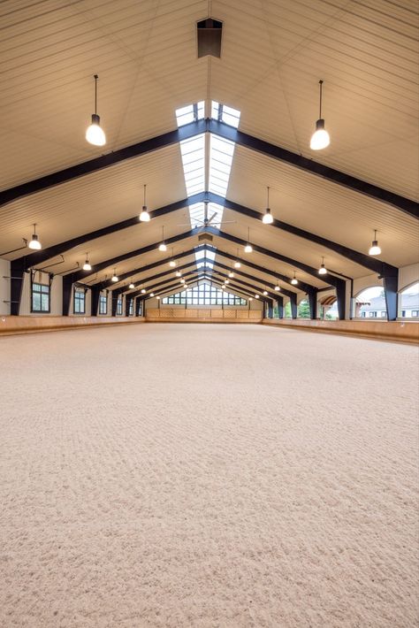 When creating this riding arena, we considered air flow, lighting, materials, the safety of horse and rider, and ease of access to the facility. With arched open-air windows on one side, and large fans overhead, air flow is never a problem. In fact, “garage doors” can be opened on the opposite length of the arena to make it a pavilion setting for maximum breeze. Large windows and skylights bring in plenty of light, while hand-bent wood bumpers keep horses safely away from the outside walls. Covered Riding Arena, Horse Riding Arena, Riding Arena, Barn Builders, Horse Arena, Dream Stables, Horse Facility, Riding Arenas, Building Company