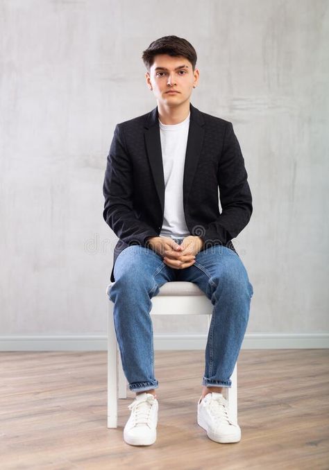 Charismatic young man sitting on chair in the middle of the room stock images Sitting Pose On Chair, Man Sitting In Chair Pose, Person Sitting Reference Chair, Men Sitting Poses, Man Sitting Pose, Sitting Pose Reference Chair, Sitting On Chair Poses, Person Sitting Reference, Man Sitting In Chair