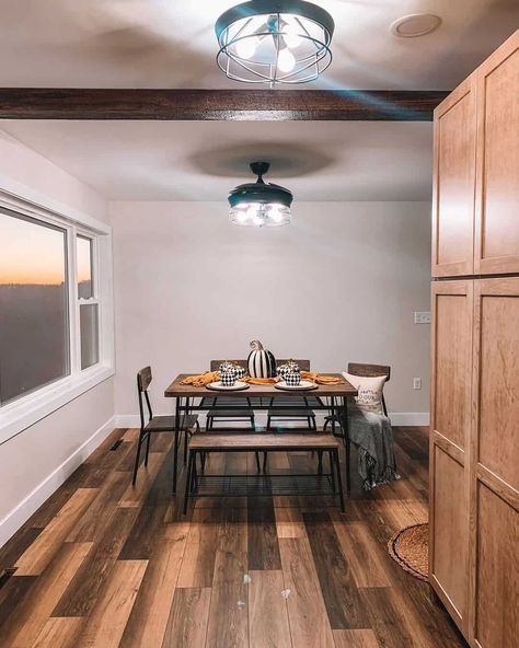 A dining room table is centered in front of a large window with white trim, allowing guests to gaze out at the sunset. There are matching pendants lights hanging from the ceiling, and autumnal decor on the table...   Image: littlefarmhouseontaylor Modern Window Trim Ideas, Modern Window Trim, Window Trim Ideas, Wrought Iron Fireplace Screen, Craftsman Style Trim, White Window Trim, Nailhead Furniture, Craftsman Window, Autumnal Decor