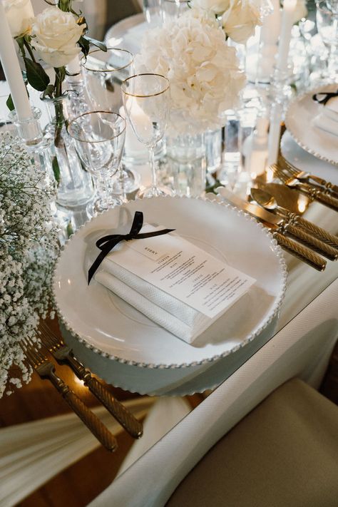 A slim white menu with black serif text and place name, joined with a black satin bow on top of a white charger plate with a mirrored table top and white flowers and clear glassware Breakfast Luxury, Sleek Wedding, Stars Wedding Invitations, Bespoke Invitations, Stationery Inspiration, Blue Envelopes, Wedding Breakfast, Star Wedding, Satin Bow