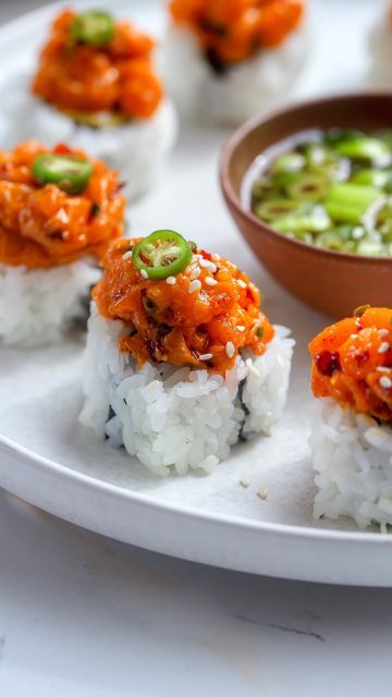 Nadia Aidi on Instagram: "Spicy Salmon Sushi Rolls ❤️ I love serving these when having people over because it is so quick, easy and pretty delish…you can use any rolls you want and any sashimi you like. The little sauce is just tamari, green onion and lemon. Ingredients: •6 oz salmon sashimi. •2 cucumber avocado rolls. •2 tbsp japanese mayo. •1 tbsp chili crunch (or sriracha). •1 tsp sesame oil. •1 tsp tamari. •2 tbsp chives. •sesame seeds. •serrano slices. Directions: 1.-chop up the salmon r Cucumber Avocado Rolls, Smoked Salmon Sushi, Avocado Rolls, Spicy Salmon Roll, Spicy Salmon Sushi, Japanese Mayo, Salmon Sushi Rolls, Chili Crunch, Sushi Recipes Homemade