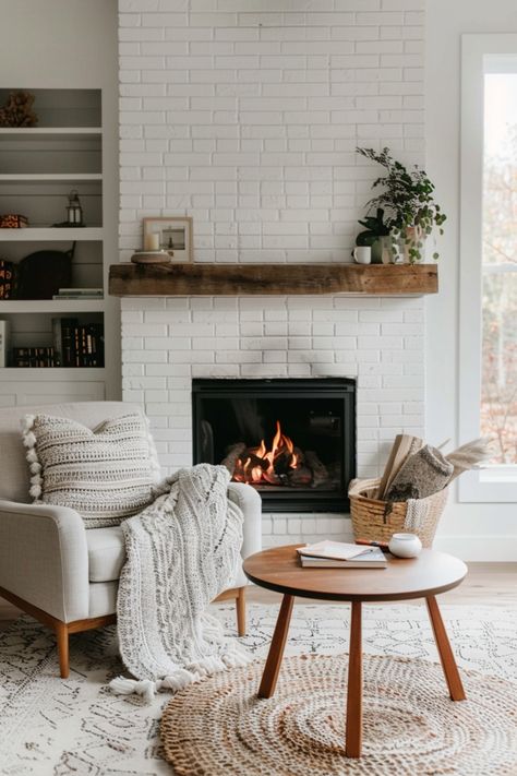 Get the top tips to create a stunning white brick fireplace in your home. White Brick Fireplace With Tv, Chair Beside Fireplace, Wood Mantle On Brick Fireplace, Living Room With White Brick Fireplace, Lights By Fireplace, Fireplace With Dark Floors, Living Room With Fireplace Paint Ideas, Dining Room With Brick Fireplace, Redone Fireplace Ideas