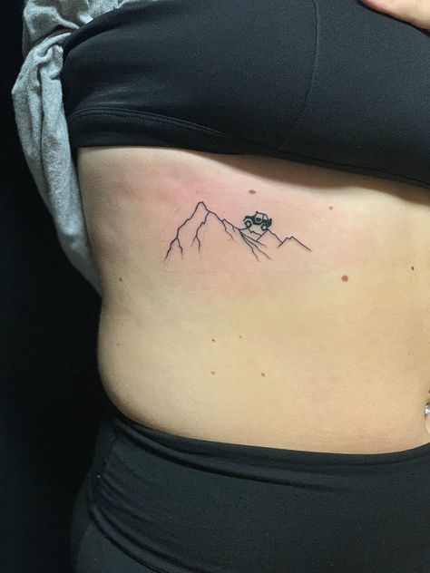 Jeep driving up mountain rib tattoo Jeep Mountains Tattoo, Minimalist Jeep Tattoo, Offroad Tattoo Ideas, Tiny Jeep Tattoo, Jeep Logo Tattoo, Jeep Wrangler Tattoos For Women, Off Road Tattoo Ideas, Simple Jeep Tattoo, Small Jeep Tattoo