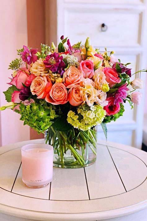 A breathtaking floral arrangement that captures the essence of a serene garden. Delicate peach and pink roses intertwine with elegant purple hellebores, lush green hydrangeas, and soft pink lisianthus, creating a harmonious and romantic composition. The arrangement is presented in a clear cylindrical glass vase, allowing the vibrant colors and intricate textures of the flowers to be showcased in their full glory. This exquisite piece is perfect for gifting or adding a touch of elegance and sophi Fall Floral Arrangements Centerpiece, Flower Arrangements Roses, Romantic Flower Arrangements, Luxury Floral Arrangements, Pink Lisianthus, Garden Tattoos, Serene Garden, Get Well Flowers, Thank You Flowers