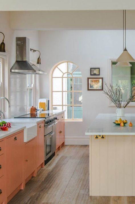 A flush of pastel pink could make this neutral kitchen look a little washed out. Instead, a lovely peachy salmon pink is used to really draw the eye. Antiqued brass hardware is a great choice if you find a brass and pink pairing too garish. Salmon Kitchen, Green Shaker Cabinets, Handleless Kitchen Cabinets, Black Cooker, Handleless Cabinets, Latest Kitchen Trends, Design Tips And Tricks, Kitchen Colour, Handleless Kitchen