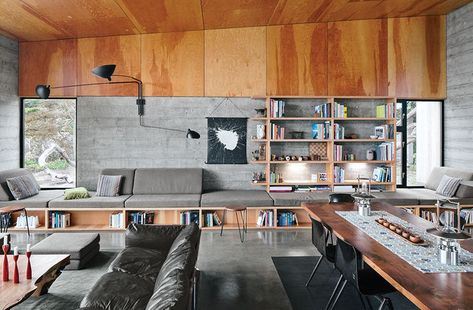 Norman Millar and Judith Sheine designed the built-ins in the living-dining area of their home in the Sea Ranch enclave in Northern California. They were made from vertical-grain Douglas fir. Vintage Dutch industrial chairs are arranged around a black walnut dining table that, like the madrone coffee table, is by Urban Hardwoods.  Photo by Mark Mahaney.   This originally appeared in Modern Home Joins a Storied Site on the Pacific Ocean. Exposed Concrete Interior, U Couch, Ranches Living, Modern Design Trends, Concrete Interiors, Modernist House, Sea Ranch, Built In Seating, Walnut Dining Table