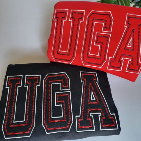 Elevate your University of Georgia fandom with our UGA Crewneck Sweatshirt, a must-have addition to your game day wardrobe. Whether you bleed red or prefer the sleek and classic black, we've got you covered in style and comfort. With its unique double outline varsity-style UGA embroidery across the front, you'll stand out in the crowd and show your Bulldog pride like never before. 🐾 Stylish Design: The standout feature of this sweatshirt is the UGA embroidery. The UGA embroidery features contrasting colors, ensuring that your Bulldog spirit shines through. It's a bold and eye-catching design that's bound to turn heads and make a statement. 🐾 Wide Range of Sizes: We cater to all UGA fans, offering sizes from small to 3XL. Finding the perfect fit has never been easier. This sweatshirt isn' Georgia College, Red And Black Shirt, Sewing Seams, Varsity Sweatshirt, White Crewneck Sweatshirt, Black Crewneck Sweatshirt, University Tshirt, Red Crewneck, Cheer Shirts