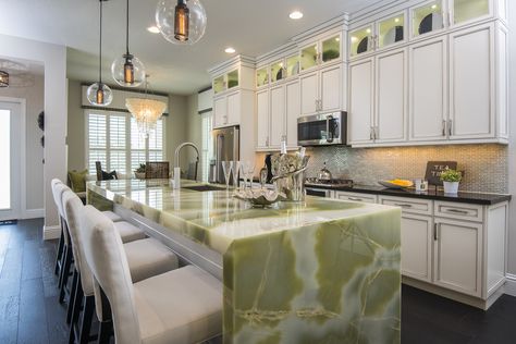 Stunning white kitchen punctuated by green onyx water-fall edge island Onyx Kitchen Island, Green Onyx Kitchen, Stone Kitchen Countertops, Onyx Kitchen, Onyx Countertops, Green Countertops, Stone Countertops Kitchen, Dark Wood Kitchen Cabinets, Tropical Kitchen