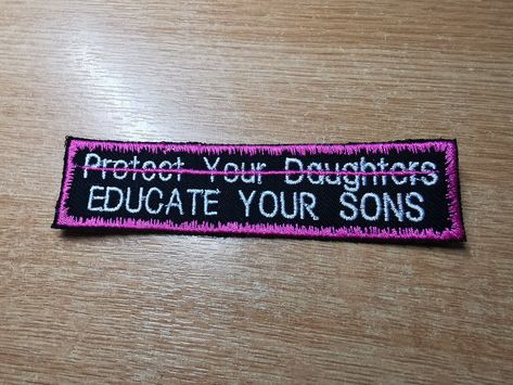 "Embroidered Patch with \"Educate your Sons\" beneath the crossed out with a scrawled flamingo pink line, \"protect your daughters\". Surrounded by the same flamingo pink, in a fuzzy snow border, this patch speaks out against the misogynistic societal belief that women are solely responsible for their own safety, and that the blame does not lie at the feet of the patriarchy.  Dimensions: 12 x 3cm The original red version is available in store! This is just a new colour variation. Feel free to re Protect Your Daughter Educate Your Son, Feminist Patches Punk, Leftist Patches, Feminist Protest, Crust Pants, Feminist Patch, Clothes Patches, Battle Vest, Punk Fashion Diy