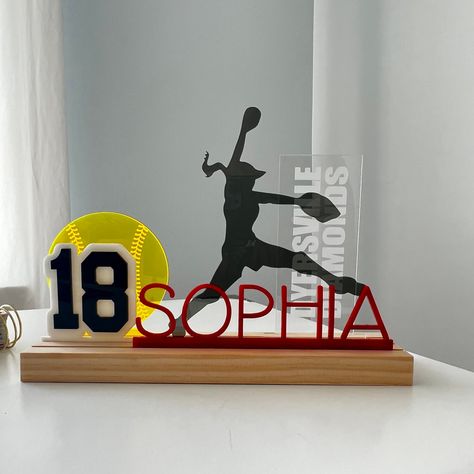 "GemLights Grandstands, New for 2022! Beautiful acrylic standing pieces in a hardwood base. Choose your colors and add-ons to make your Grandstand a one-of-a-kind personalized gift. Your Grandstand Set Includes: 1. Wood base---- 10\"x3\" with three grooves for Grandstand Inserts. 2. Name---- Acrylic Insert in your choice of color and font. 3. Silhouette---- Acrylic Insert in your choice of color. 4. Accent Piece (Neon yellow ball)---- Acrylic Insert in your choice of color 5. Team Name Tower --- Softball Senior Night Dugout Decorations, Unique Softball Gifts, Softball Picture Frames Diy, First Softball Game Gift, Softball Room Decor, Girls Softball Room, Personalized Softball Gifts, Softball Room, Volleyball Bag Tags