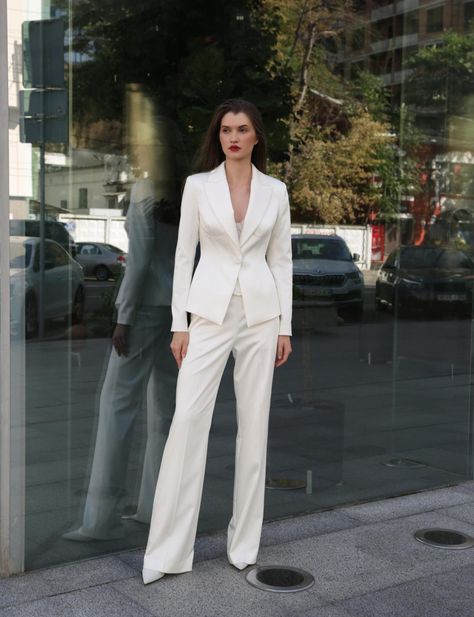 Wedding suits for women are on the rise. Tailoring has taken over women's clothing in the past few years, creeping into dress codes everywhere, from offices to dinner parties. Made from luxurious stretch satin, this set includes gently-flared pants and a sculpted one-button blazer with statement details. A lace drop waist corset completes the look - it's a great investment that will be worth every penny! Material: stretch satin Fabric composition: 71% Polyester, 15% Viscose, 8% Spandex Corset boning: yes Built-in cups: no Lining: yes Neckline: sweetheart / V-neck Sleeves: long sleeves Pants length from waist: 116 cm (45") Model is: 180 cm / 85-63-92, wearing size 4 in ivory color* *The dress color might be a little different from what's shown in the photos because of the way colors look on Wedding Suits For Women, Women Suits Wedding, Bridal Suit, Stretch Satin Fabric, Waist Corset, Corset Boning, Satin Jacket, Couture Bridal, Satin Jackets