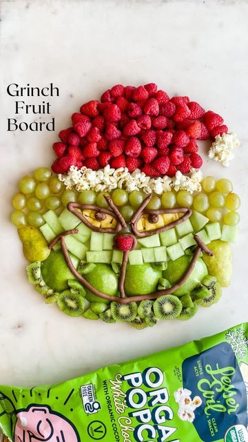 Steph | Healthy Family Recipes & Food Hacks on Instagram: "This Grinch Fruit Board is so fun for a Christmas party! It’s the perfect healthy snack for all of your little Whos! ⭐️ Follow for more simple, healthy holiday recipes ⭐️ I saw @playpartyplan share a Grinch candy board, and I knew I wanted to make one with fruit in collaboration with @lesserevilsnacks. All you need are a bunch of green fruits, red fruit, yellow fruit, chocolate icing, and popcorn. We love @lesserevilsnacks White Chocol Healthy Christmas Fruit Tray, Christmas Fruit Tray For Kids, Grinch Fruit Tray, Christmas Fruit Ideas, Christmas Fruit Tray Ideas, Holiday Fruit Tray, Christmas Fruit Snacks, Holiday Fruit Platter, Christmas Fruit Tray