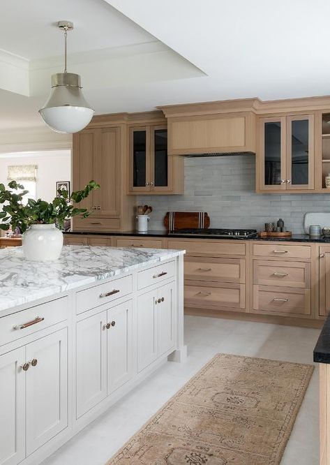 Brown kitchen features a tan runner place behind a dove gray island topped with a white and gray polished marble countertop lit by two Kelly Wearstler Precision Pendants hung from a tray ceiling. Revere Pewter Island, Bm Revere Pewter, White Oak Kitchen Cabinets, Cabinet Trends, White Oak Kitchen, Kitchen Cabinet Trends, Brown Kitchen Cabinets, White Island, Kitchen New York