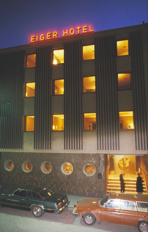 Photography of a hotel entrance with cars upfront, yellow lit room light and a neon sign 70s Hotel Aesthetic, 60s Hotel, Condominium Entrance, Dystopian Book, Retro Hotel, Miami Hotel, Dream Hotel, Background References, Business Architecture