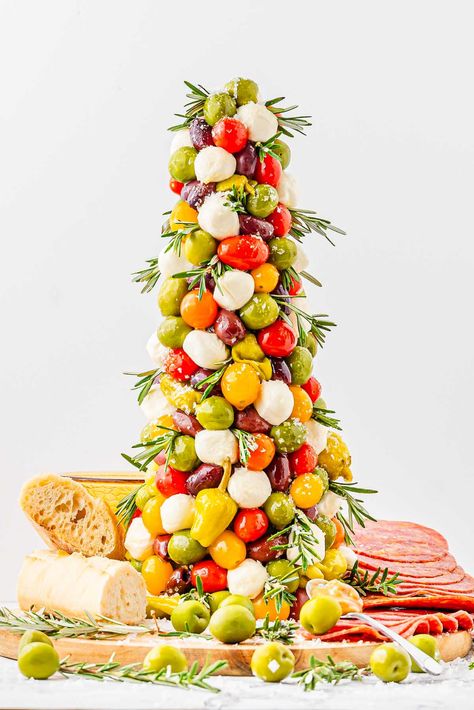 It's never too early to start planning recipes for your Christmas dinner and festive appetizers during the holiday season (or even just before!) This antipasto tree is an Italian take on an antipasto platter, boasting tomatoes, little cheese balls, green olives, and more. It's worth making several of these because, as well as being a delicious appetizer, it makes a gorgeous and edible table centerpiece. You'll be feeling festive putting this cute antipasto Christmas tree appetizer together! Antipasto Tree, Pasta Tree, Christmas Charcuterie Board Ideas, Tree Appetizer, Edible Wreath, Christmas Charcuterie Board, Christmas Tree Store, Pickled Cauliflower, Christmas Yummies