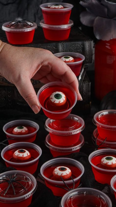 These Halloween eyeball jello shots are fun and easy to make. They're sure to be popular at your Halloween party and everyone is going to want one, or even a matching pair! Dial up the creepy factor by making some Halloween themed food and drinks. You only need 4 ingredients to make these - jello powder, boiling water, berry vodka, and candy eyeballs. You can make them ahead and just keep them in the refrigerator until the party is underway and it's time to serve up these ghoulish jello shots! Spooky Jello Shots, Spooky Jello, Eyeball Jello Shots, Eyeball Jello, Syringe Jello Shots, Vodka Water, Jello Shot Cups, Halloween Jello Shots, Halloween Recipes Drinks