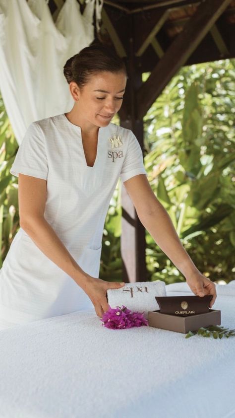 A spa therapist wearing a custom embroidered white spa tunic and spa trousers. Spa Therapist Uniform, Resort Uniform Ideas, Massage Therapist Uniform Ideas, Massage Therapist Outfit, Spa Uniform Ideas, Resort Uniform, Massage Beds, Therapist Outfit, Hotel Uniforms