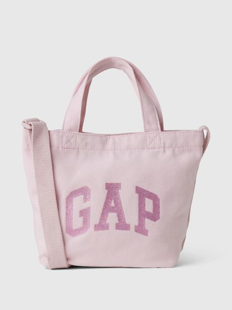 Soft cotton tote bag.  Straps at top.  Adjustable shoulder strap.  Gap arch logo in glitter or sequins at front.  Inner pocket.  This product was made in a factory that invests in gender equality and women’s empowerment.  Through RISE Reimagining Industry to Support Equality) and Gap Inc. ’s program P. A. C. E.  Personal Advancement & Career Enhancement), we support people who make our clothes to build the skills, knowledge, confidence, and resilience needed to advance in work and life.  Learn m Cute Tote Bags For School, Lululemon Tote Bag, Sparkle Logo, Cloth Tote Bags, Tote Bag Straps, Gap Bag, Pink Bags, Luxury Tote Bags, Logo Tote Bag