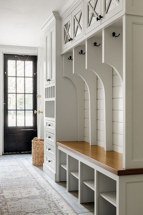 If you have a busy household, a mudroom can do wonders for your space. These small yet highly functional areas can give you extra storage and a place where everyone can hang their coats and umbrellas or store their muddy shoes. While traditionally a 'mudroom' may be to take off your muddy shoes, they're also a great place to hang wet towels at a beach house, put up your skis at a mountain home, or drop your bags and shoes in a city home. Really, the mudroom is a hub where you can stop and '... Mudroom Step Up To Kitchen, Mudroom With Catch All, Entry Storage Ideas Small, Interior Design Mudroom, Built In Benches, Mudroom Renovation, Built In Cubbies, Kitchen Mudroom, Vstupná Hala