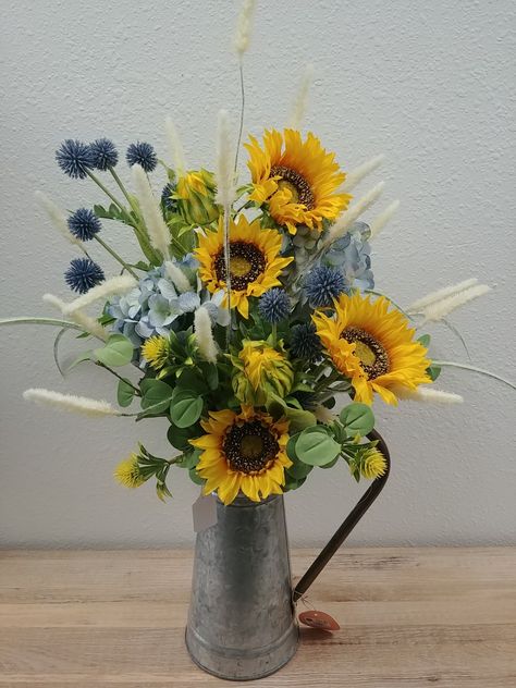 Blue hydrangeas, blue and yellow pom flowers, feathered cat tails and sunflower for a pop of color.🌻 Sunflower Floral Arrangements, Sunflower Arrangement, Sunflower Centerpieces, Sunflower Arrangements, Floral Boutique, Cemetery Flowers, Turquoise Flowers, Western Theme, House Projects