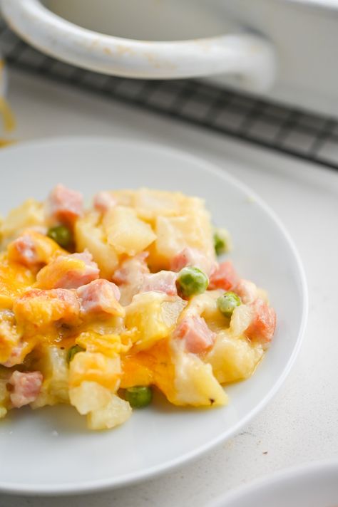 Cheesy Ham Potato Casserole is a hearty, comforting way to use leftover ham. Full of diced ham, peas, potatoes and a creamy cheese sauce. It'll be family favorite! Casserole With Diced Potatoes, Broccoli Ham Recipes, Ham And Diced Potato Casserole, Recipes With Ham And Potatoes, Diced Potatoes And Ham Casserole, Ham Potato Casserole Recipes, Ham And Potato Casserole Recipes, Diced Ham Recipes Dinner, Ham And Cheese Potato Casserole