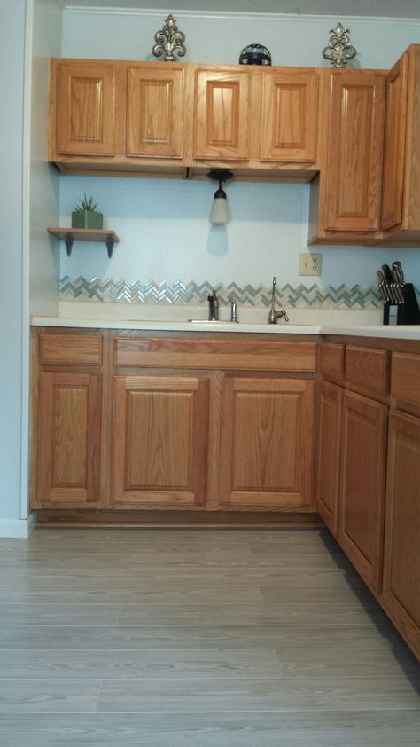 Honey oak kitchen cabinets with gray Pergo Willow Lake Pine floors and herringbone tile backsplash Honey Oak Kitchen Cabinets, Honey Oak Kitchen, Wooden Kitchen Floor, Light Oak Cabinets, Kitchen Cabinets And Flooring, Cabinets Ikea, Cabinets Gray, Cabinets Colors, Kitchen Gray