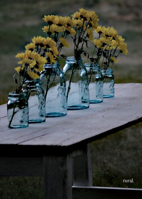 blue mason jars with yellow flowers grace this white farmhouse table White Farmhouse Table, Mason Jar Arrangements, Progressive Dinner, Blue Centerpieces, Blue Mason Jars, Farmhouse Crafts, Jar Decor, Ball Mason Jars, Mason Jar Centerpieces