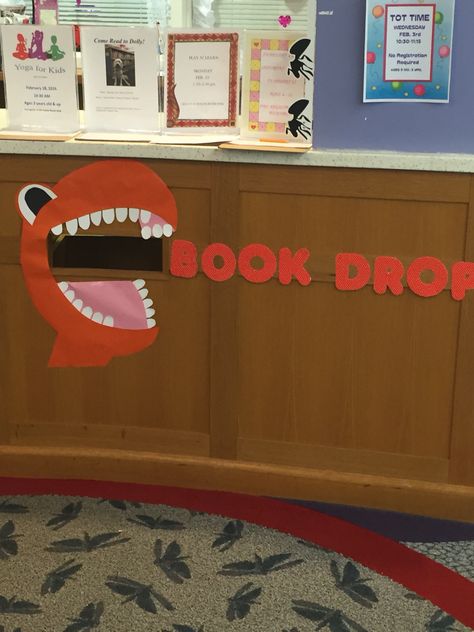 Dinosaur book drop Dinosaur Library Display, Dinovember Library Display, Library Puns, Middle School Library Displays, Christmas Library Display, Library Walls, Book Return, Book Puns, School Library Decor