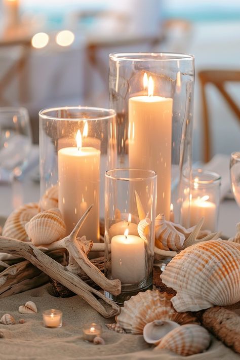 For a soft, romantic touch, candle centerpieces are a perfect choice for wedding tables. See more ideas here. Eucalyptus Candle Centerpiece, Beach Themed Wedding Centerpieces, Beachy Centerpieces, Beach Wedding Table Centerpieces, Beach Wedding Table Decor, Wedding Candle Centerpieces, Shell Centerpieces, Romantic Centerpieces, Beach Wedding Tables