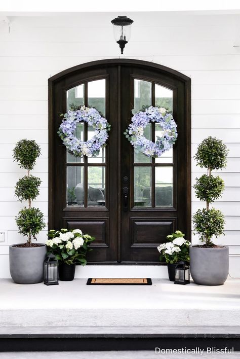 Front Door Bushes Entrance, Front Porch Decor With Double Doors, Double Door Porch Decor, Topiaries Front Porch, Bungalow Front Porch Decor, Double Door Entrance Decor, Black Front Door Lanterns, Front Porch Decor Black Door, Woodland Beds