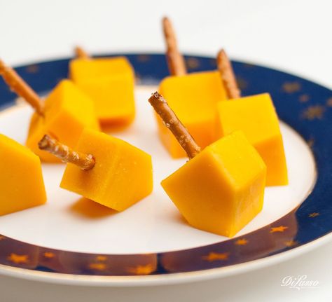 Dreidel, dreidel dreidel, I made you out of CHEESE. We firmly believe that food should be fun. Here’s a festive and easy snack the whole family can enjoy at holiday gatherings.   Directions  	Order 1” thick DI LUSSO® deli cheese slices. Mix and match cheeses. We love mild cheddar and Pepper Jack. 	Cut into cubes and trim cube ends at an angle. 	Insert pretzel sticks and serve. Hanukah Menu, Hannukah Party, Hanukkah Dinner, Jewish Holiday Recipes, Hanukkah Crafts, Hanukkah Food, Chanukah Party, Chanukah Decor, How To Celebrate Hanukkah