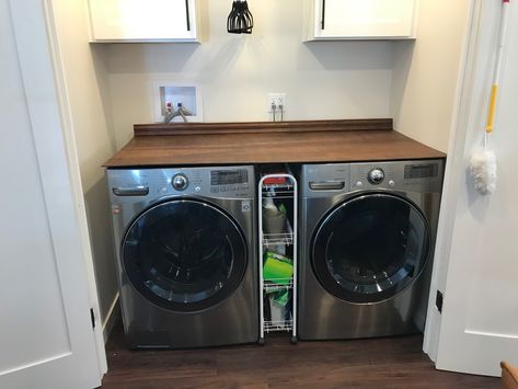 I wanted a solid cover for my washer dryer. My old laundry had a butcher block top that was on 2x4s attached to the walls but it wasn’t easily removeable. And I wanted to be able to store brooms on the side of the washer. I would have paid money to buy something but apparently no such product exists. So I made this for about $35.00. 5mm birch underlayment plywood cut to size at Home Depot. A chair rail cut to size. A pack of gripping pads for underneath and some stain I already had. Washer Dryer Set Up, Washer And Dryer Top Cover, Diy Butcher Block, Butcher Block Top, Laundry Room Remodel, Chair Rail, Wooden Planks, Laundry Room Design, Wooden Tops