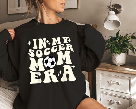 In My Soccer Mom Era Shirt, Soccer Mom Sweatshirt, Game Day Shirt, Soccer Sport Shirt, Cool Mom Club Shirt, Mom Era Sweatshirt, Mom Life Tee 👕PRODUCT INFORMATION This classic unisex jersey short sleeve tee fits like a well-loved favorite. Soft cotton and quality print make users fall in love with it over and over again. These t-shirts have-ribbed knit collars to bolster shaping. The shoulders have taping for better fit over time. Dual side seams hold the garment's shape for longer. When the design color matches the shirt color, we will automatically change the design color to white/black to make it stand out. If you want to keep the design color, please message or note for us. 🛒HOW TO ORDER 1. Check photos for sizing and color options  2. Select size and color from the drop-down menus  3 Soccer Shirts Designs, Xmas Gifts For Mom, Mom Era, Cool Mom, Festival Shirts, Moms Club, Game Day Shirts, Soccer Mom, Club Shirts