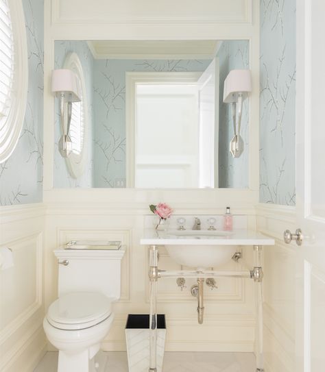 This elegant, transitional bathroom boasts gorgeous wainscoted walls with upper blue wallpaper embellished with silver branch patterns. Blue Powder Room, Cream Bathroom, Powder Room Small, Decor Baie, Transitional Bathroom, Powder Rooms, Blue Bathroom, Bathroom Wallpaper, Bath Remodel