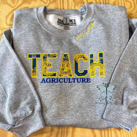 Inspire success with our TEACH Agriculture FFA Personalized Embroidered Crewneck Sweatshirt! Made with pride and precision, this customizable sweatshirt showcases your passion and dedication to the FFA organization. Stay warm and represent your commitment to agriculture education in style. THIS IS A PHYSICAL PRODUCT. CREWNECK IS UNISEX. CREWNECK IS EMBROIDERED. Ffa Jacket Shadow Box Ideas, Ffa Advisor Gifts Ideas, Ag Classroom Decorations, 4h Shirts Design Ideas, Ffa Week Ideas, Ffa Apparel, Ffa Teacher, Reverse Embroidery, Ffa Jacket