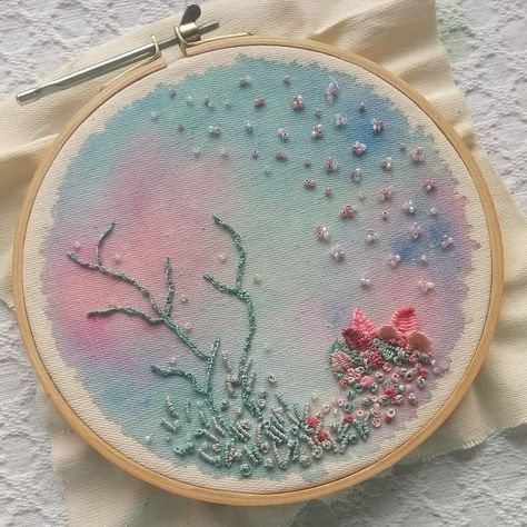 Picture of an embroidery hoop, background made in watercolor in pastel blue, green and pink, sea creatures made with thread and beads, mostly green and pink. Under The Sea Embroidery Ideas, Sea Theme Embroidery, Embroidery Under The Sea, Watercolor With Embroidery, Under The Sea Textiles, Watercolor And Embroidery On Fabric, Embroidery And Watercolor, Sea Embroidery Ideas, Under The Sea Embroidery