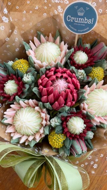 Crumbs! Custom Cupcakes🧁 on Instagram: "CUPCAKE BOUQUET WRAPPING in 50s!🌿🤍🌿🤍 A quick little video for you! This is how I wrap a 7-cupcake bouquet. The bouquet design is my “Protea & Fynbos” posy! #cupcakes #buttercreamflowers #reelsinstagram #cupcakebouquet #weddingcupcakes #caketutorial #bakingtips #bouquetwrapping #floralcupcakes #edibleart #cupcakeart #capetown #cakereels#cakevideo #cakedecorating #flowercupcakes #cakeart #reels#customcupcakes #edibleflowers #cupcakedecorating #houtbay #cupcakelove #cakeartist #cupcakesofinstagram" Protea Cupcakes, Cupcake Bouquet Tutorial, Buttercream Flowers Tutorial, Cupcake Flower Bouquets, Cupcake Flower, Cupcake Bouquets, Bouquet Wrapping, Geode Cake, Butter Icing