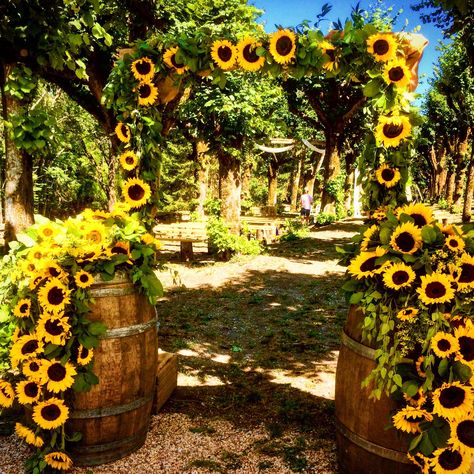 Gorgeous arch creating an entrance to a woodland ceremony complete with sunflower swing Sunflower Stage Decor, Sunflower 15 Dress, Sunflower Arch Wedding, Sunflower Quinceanera Theme, Sunflower Wedding Arch, Sunflower Arch, Whiskey Barrel Flowers, Woodland Ceremony, Sunflower Decorations