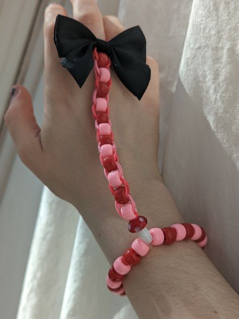 a hand in front of a white curtain with a red and pink alternating pony bead bracelet around the wrist with a little mushroom bead connecting it to a longer piece with the same pattern that wraps around the finger with a bow on the end Kandi Glove, Pink Kandi, Skeleton Gloves, Cute Desktop Wallpaper, Loom Bands, My Posts, Desktop Wallpaper, Loom, Skeleton