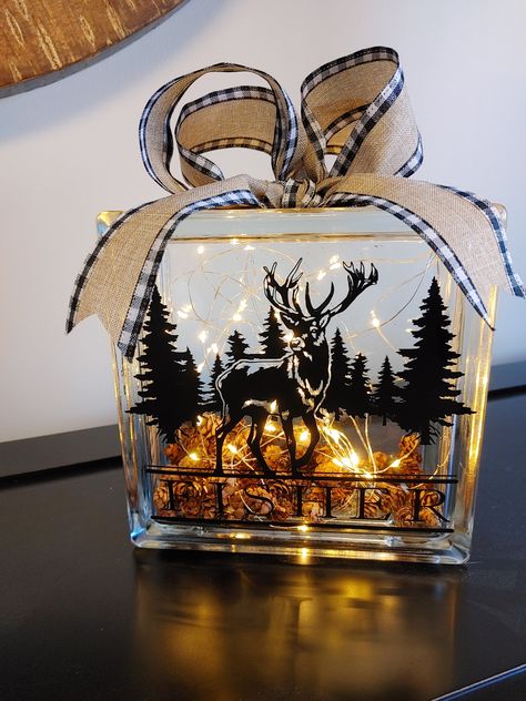 "Add some cozy and rustic charm to your home with this unique glass block light. This 7.5\" glass block contains a pair of battery powered string lights that create a warm and inviting glow. The front of the block is decorated with a deer and trees design that gives it a woodland feel. You can also personalize it with your family name for a custom touch. The block is finished off with a bow made of burlap ribbon with buffalo plaid edging. This glass block light is perfect for any room in your ho Ideas For Glass Blocks, Fall Glass Block Ideas, Glass Block Decorating Ideas, Glass Insulator Crafts, Glass Block Crafts Diy, Glass Box Ideas, Glass Blocks Ideas, Decorated Glass Blocks, Glass Block Ideas