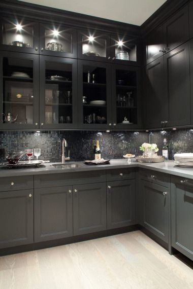 Gorgeous black kitchen design with oak wood floors, black shaker kitchen cabinets, gray quartz countertops and glass-front black glass tiles backsplash.  the lighting makes this too dark kitchen  amazingly inviting Black Shaker Kitchen Cabinets, Black Shaker Kitchen, Cabinets Gray, Black Kitchen Design, Tiles Backsplash, Front Kitchen, Gray Quartz, Glass Cabinets, Loft Ideas