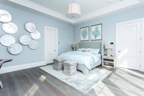 Large master bedroom featuring rustic hardwood flooring and light blue walls with multiple stylish wall decors. Powder Blue Bedroom, Guys Bedroom, Baby Blue Bedrooms, Light Blue Rooms, 2020 Bedroom, Light Blue Bedroom, Blue Room Decor, Blue Bedroom Ideas, Blue Bedroom Walls