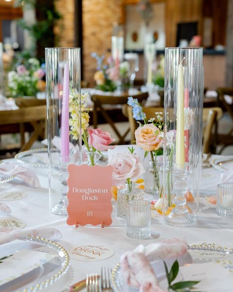 you kidding me 🥲 these pastel tapers added so much to this tablescape!! A sweet bud quartet paired with a trio of taper candles is one of our favorite ways to add a little something something to a guest table. here, we opted for mini centerpieces on some of our farm tables + invested in smilax vines to give life to the venue overall - which is something ALL your guests can enjoy, no matter which table they’re sat at. It’s all about creating an atmosphere! Planning @perfectlyplannedtx Venue... Oval Table Wedding Decor, Guest Table Centerpieces Wedding, Pastel Bud Vase Centerpiece, Low Cost Wedding Table Decor, Table Setting Spring Wedding, Wedding Table Centerpieces Bud Vases, Pastel Flower Table Decorations, Bud Flower Centerpieces, Candle Vase Centerpieces