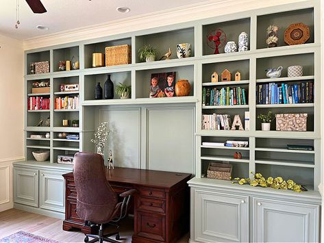 Home office with light sage green cabinet storage. Huge library style shelves in a home office with a stained wood desk. Sage Green Bookshelves, Light Green Bookshelf, Sage Green Built In Bookshelves, Sage Bookshelf, Sage Green Bookshelf, Sage Green Cabinet, Fun Boys Bedroom Ideas, Green Bookshelves, Grey Bookshelves